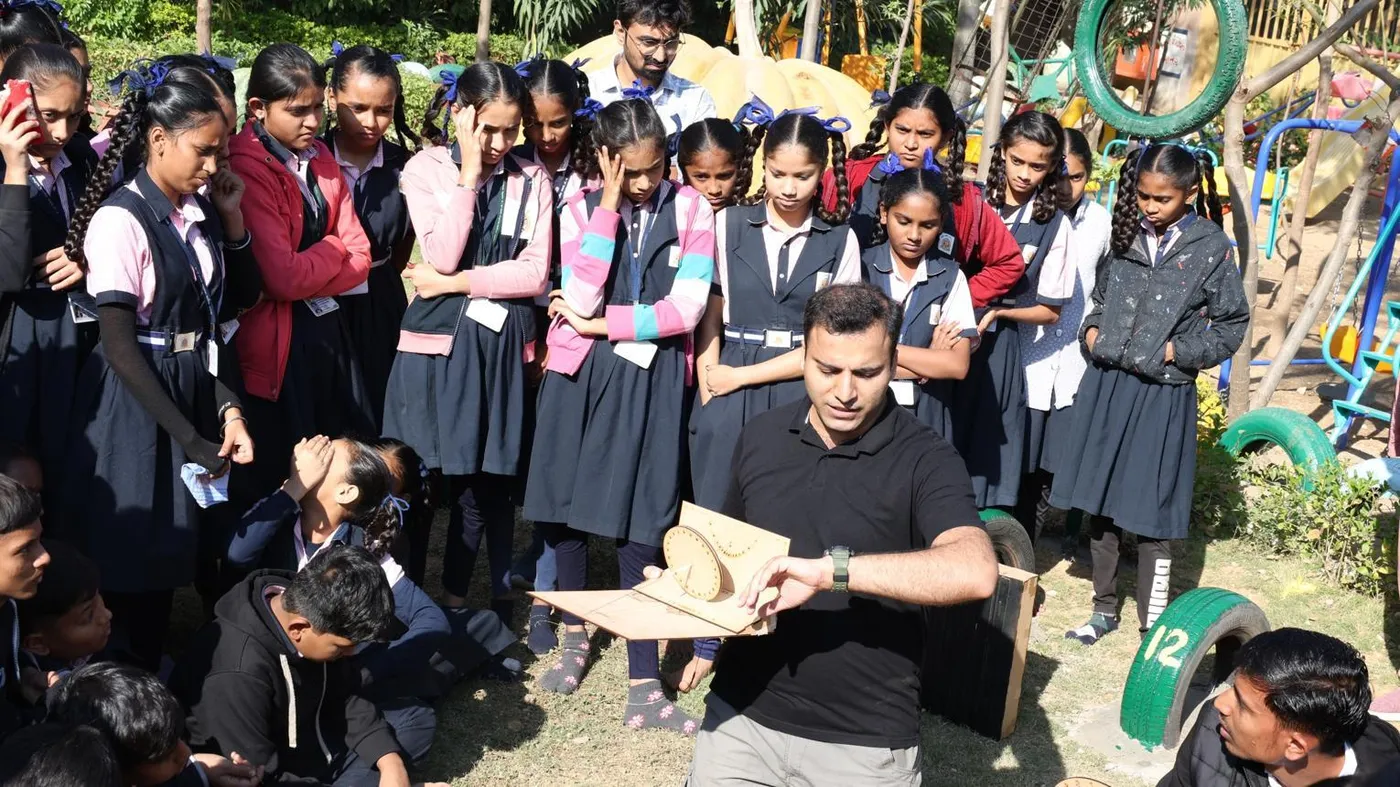 School students watching an outdoor science toy demonstration